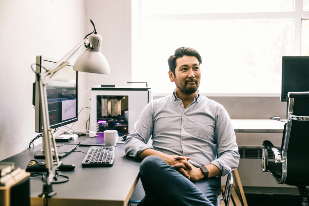 The man sits at the table with a computer